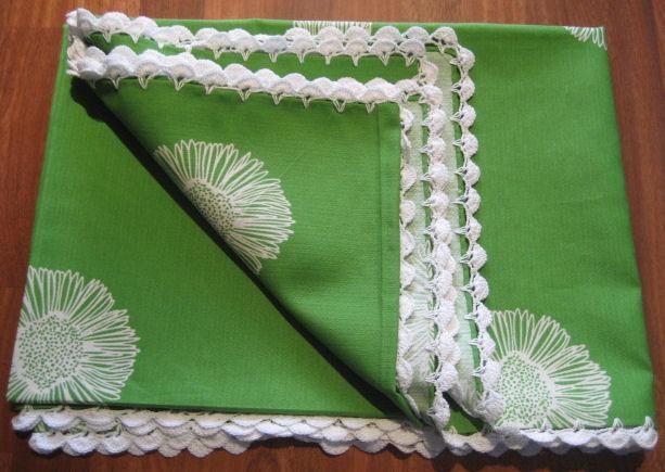 Mantel verde con flores blancas rematado a ganchillo