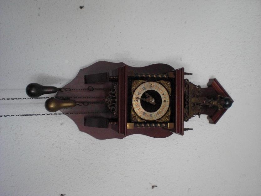 reloj en madera con pendulos de bronce