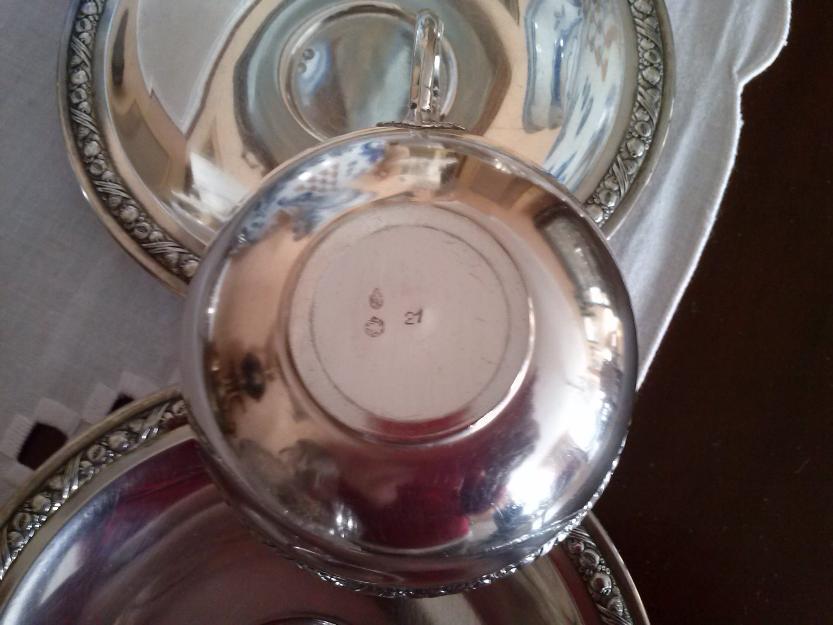 Dos tazas de plata con porcelana y plato. Tienen contraste